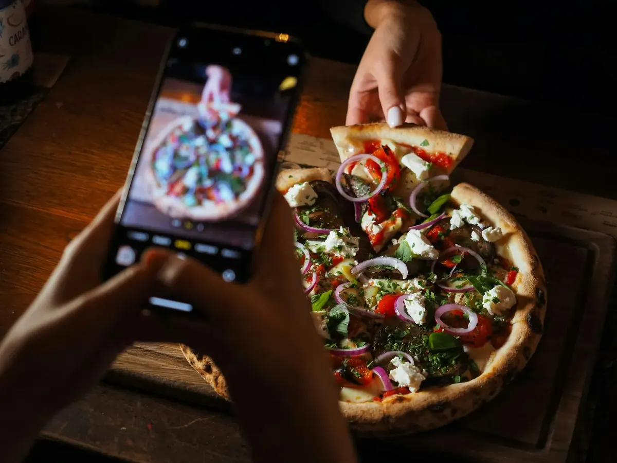 Pizza z pieca opalanego drewnem fotografowana telefonem w Villa Toscana Nowy Targ