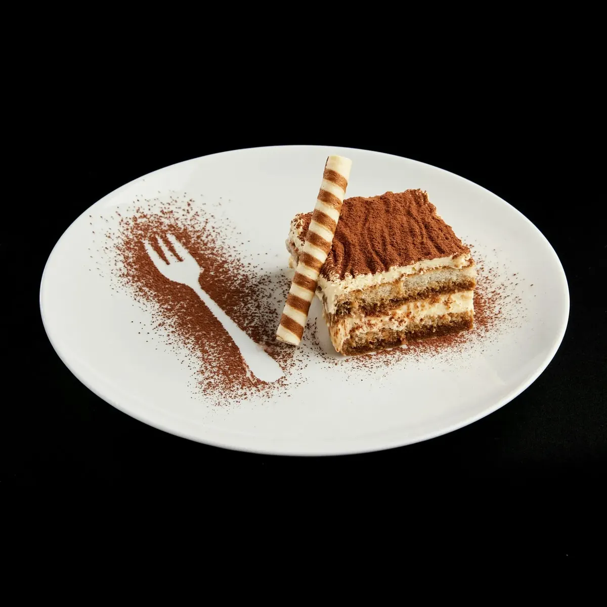 Tiramisu posypane kakao na białym talerzu